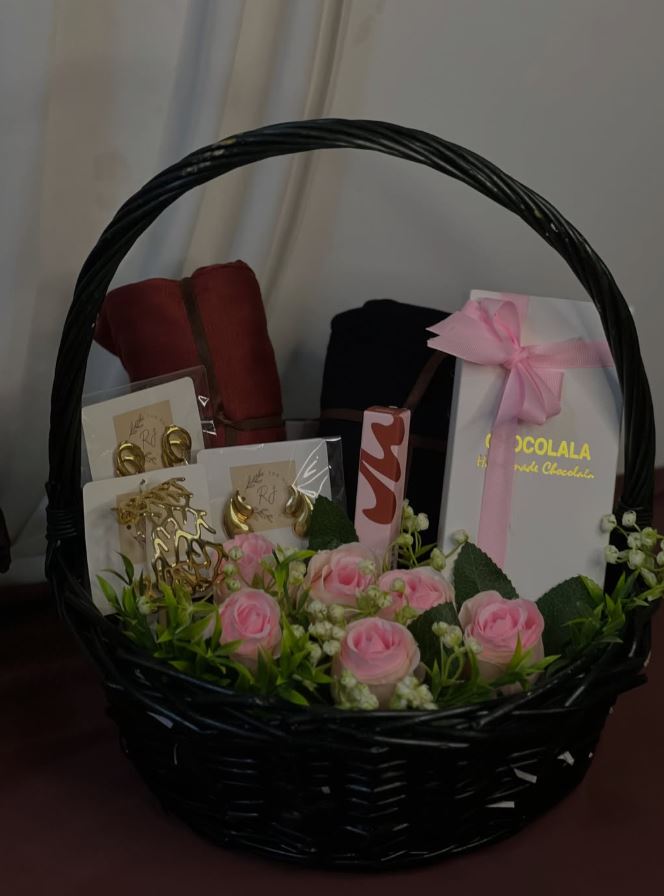 Gift hamper with pink roses, chocolates and personal items