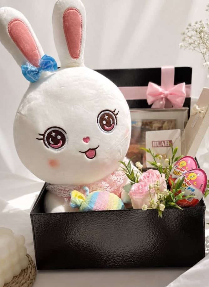 Gift box with plush bunny toy and flowers